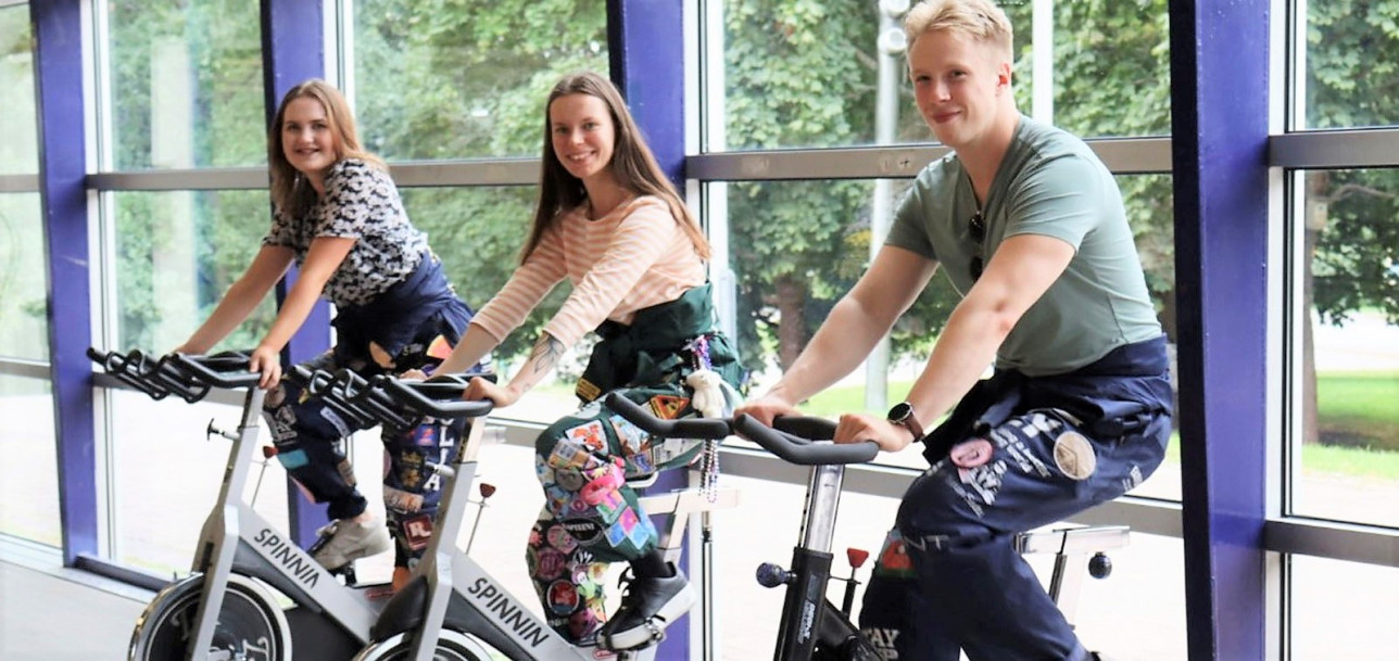 Opiskelijat pyöräilemässä opiskelijahaalareissa kuntopyörillä Kupittaan urheiluhallissa.