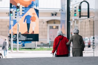Kaksi ikäihmistä kävelemässä kaupungilla.