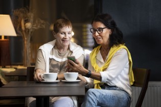Kaksi naista kahvipöydän ääressä.