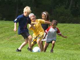 Joukko lapsia pelaa jalkapalloa