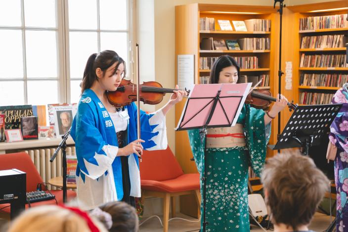 Kaksi japanilaistaustaista naista soittavat viuluja. (Kuva: Akinori Ikeda)