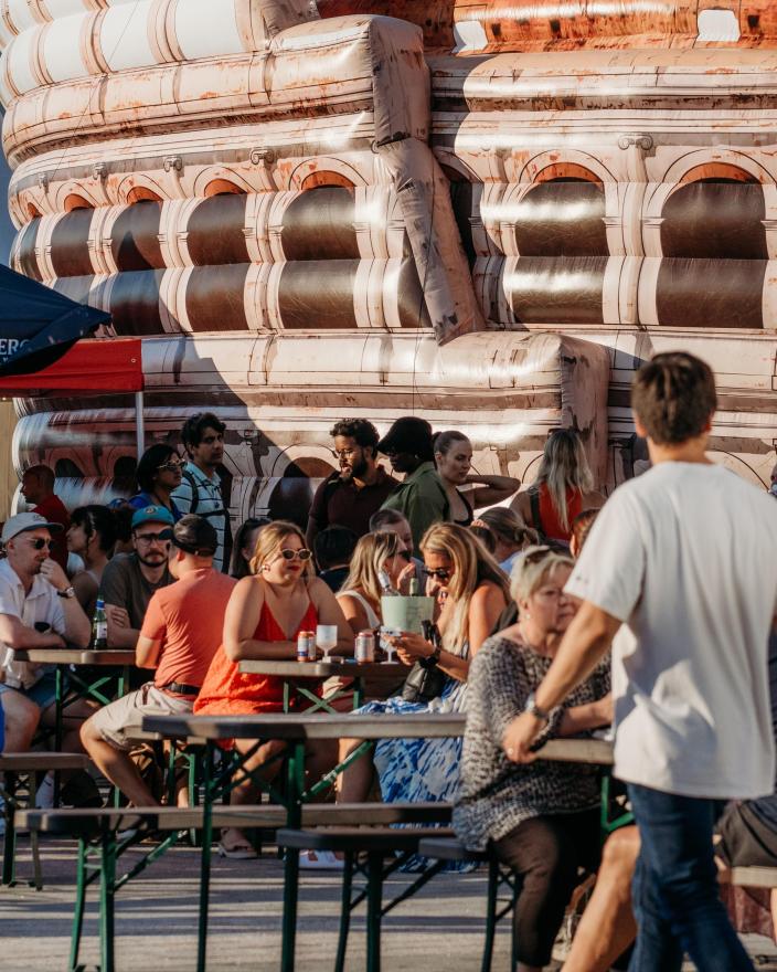 Ihmisiä istuu terassilla viettämässä aikaa Little Italy -ruokafestivaaleilla.