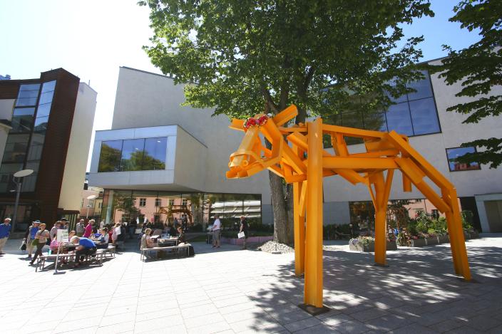 Ihmiset istuskelevat Turun pääkirjaston sisäpihalla kesällä. (Kuva: Vilma Hildén)