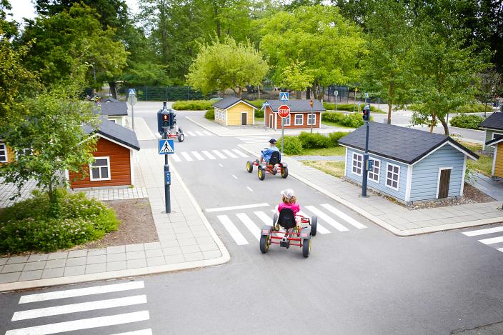 Lapset ajelevat polkuautoilla liikennepuistossa kesällä. (Kuva: Ville Solkinen)