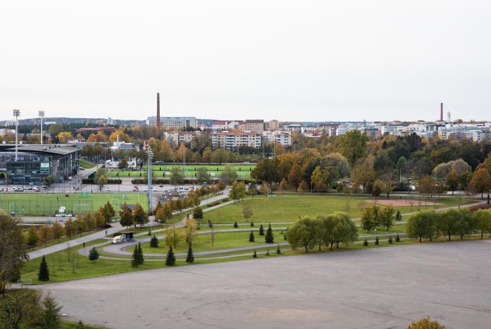 Kuvassa puisto, jossa rakennuksia, puita, nurmea ja hiekkakenttä (Kuva: Heikki Räisänen)