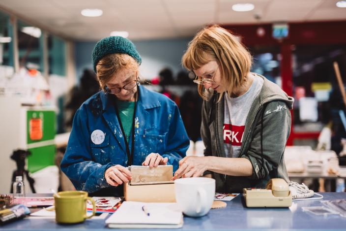 Kaksi naista selaamass atarvikkeita Aikamatka-teoksessa. (Kuva: Jussi Virkkumaa)