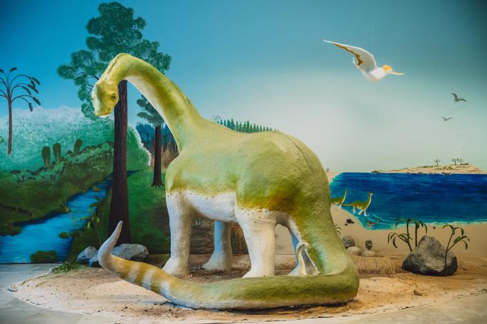 Kuvassa paperimassasta valmistettu suuri dinosaurus Aikamatka 20360 -tilataideteoksessa.