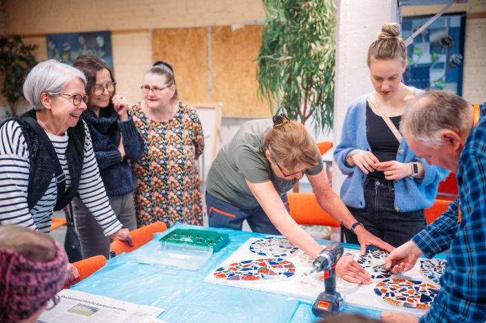 Ihmisiä tekemässä mosaiikkitaidetta. (Kuva: Jussi Virkkumaa)