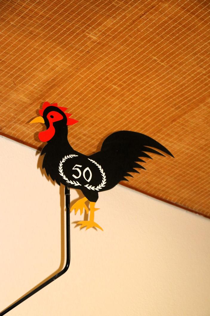 Aapiskukko seinällä, kukossa luku 50.