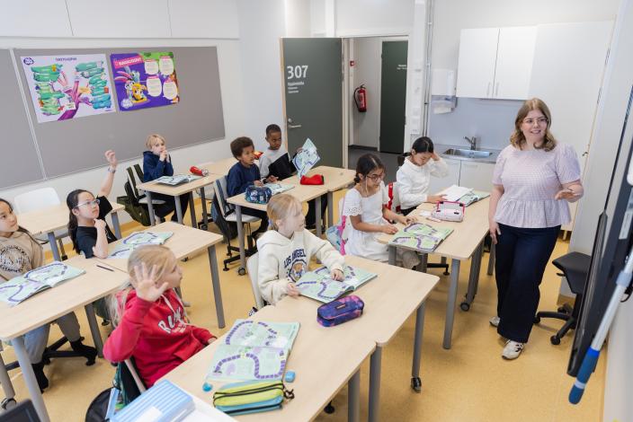 Opettaja ja oppilaita luokkahuoneessa. (Kuva: Linda Svarfvar)