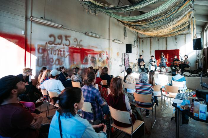 Yleisöä kuuntelemassa konserttia vanhassa ratikkahallissa. (Kuva: Jussi Virkkumaa)