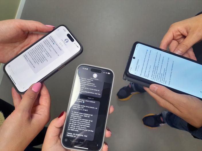 Lähikuvassa on kolme kännykkää, joihin on Annie-sovellus avattuna.