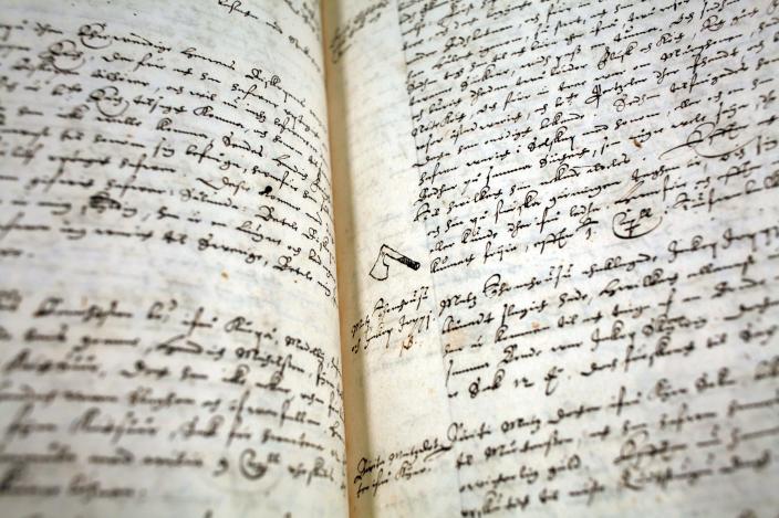 Vanha dokumentti, musteella käsin kirjoitettua tekstiä ja pieni piirretty mestauskirves. (Kuva: Sanna Sinervo)