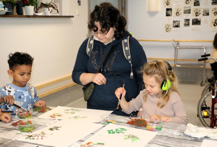Två barn och en dagisfröken pysslar.  (Foto: Hannele Sivonen)