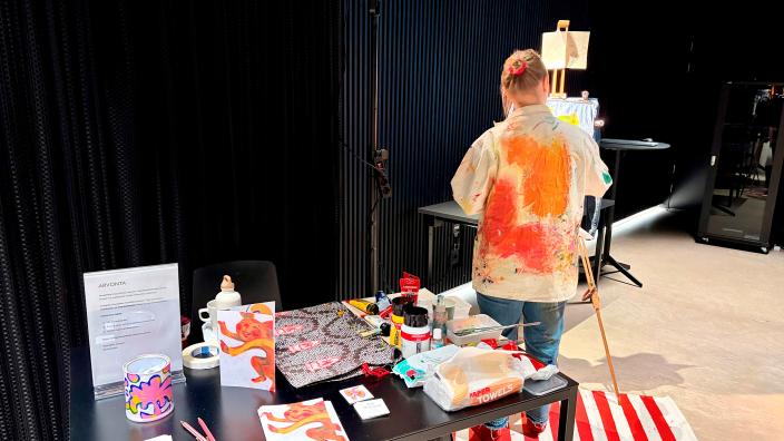 Elli Maanpää maalaamassa CCC-projektin loppuseminaarissa live-taideteosta farkkutakille. (Picture: Julia Innilä)