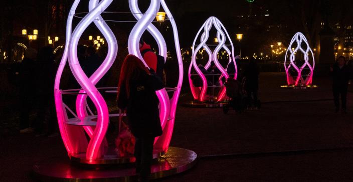 Kuvassa kapselimaisia valotaideteoksia pimeydessä.