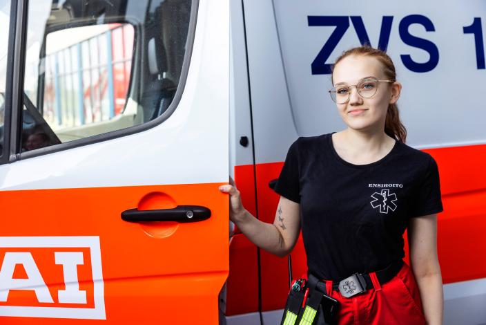 En bild på en ambulanssjukvårdarstudent som står framför en ambulans. (Foto: Jussi Vierimaa)