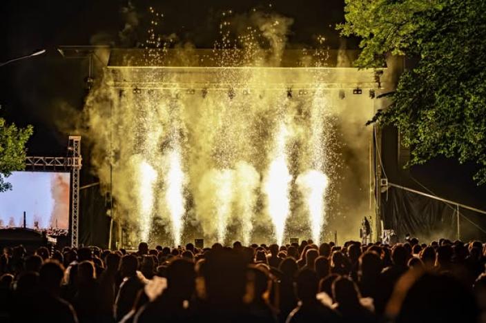 Festivaaliyleisö seuraa iltakonserttia, kun lavalla syttyvät näyttävät pyrotehosteet. (Kuva: Tero Kukkonen)