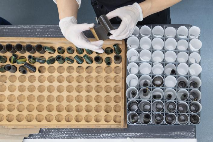 Käsineillä suojatut kädet pakkaavat filmiä muuttoa varten. (Kuva: Ville Mäkilä)