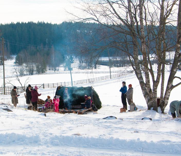 Kuralankylämäessä ihmisiä talvella nuotion äärellä. (Kuva: Joel Karlsson)
