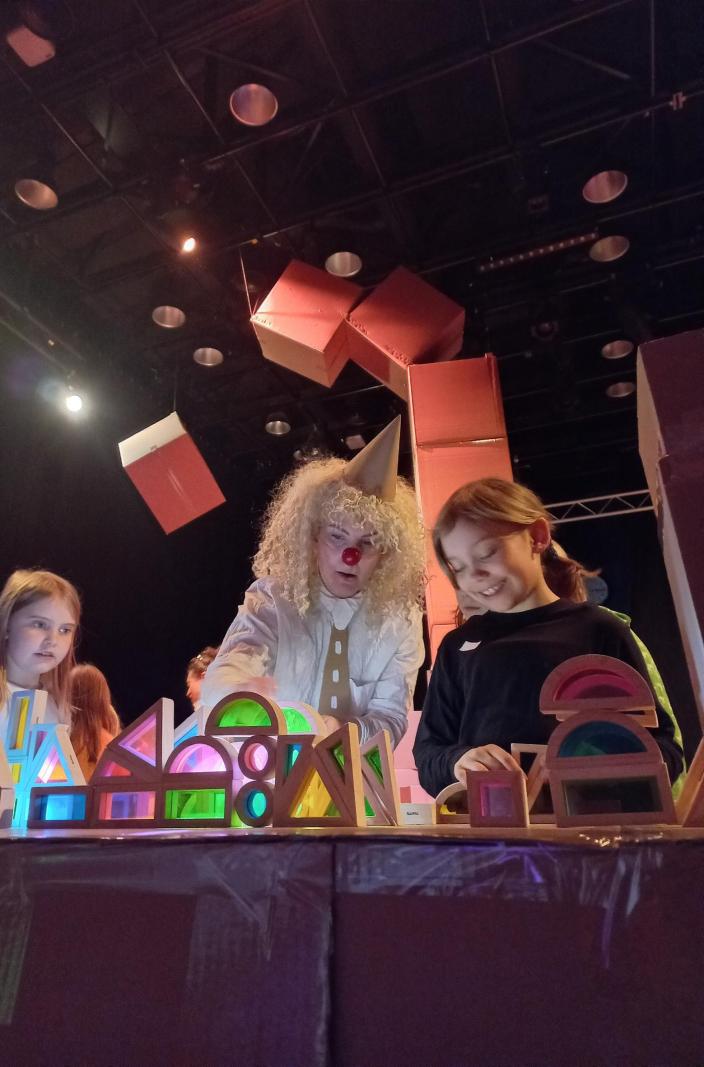 En clown och barn bredvid olika formade bitar. (Foto: Susanne Nieminen)