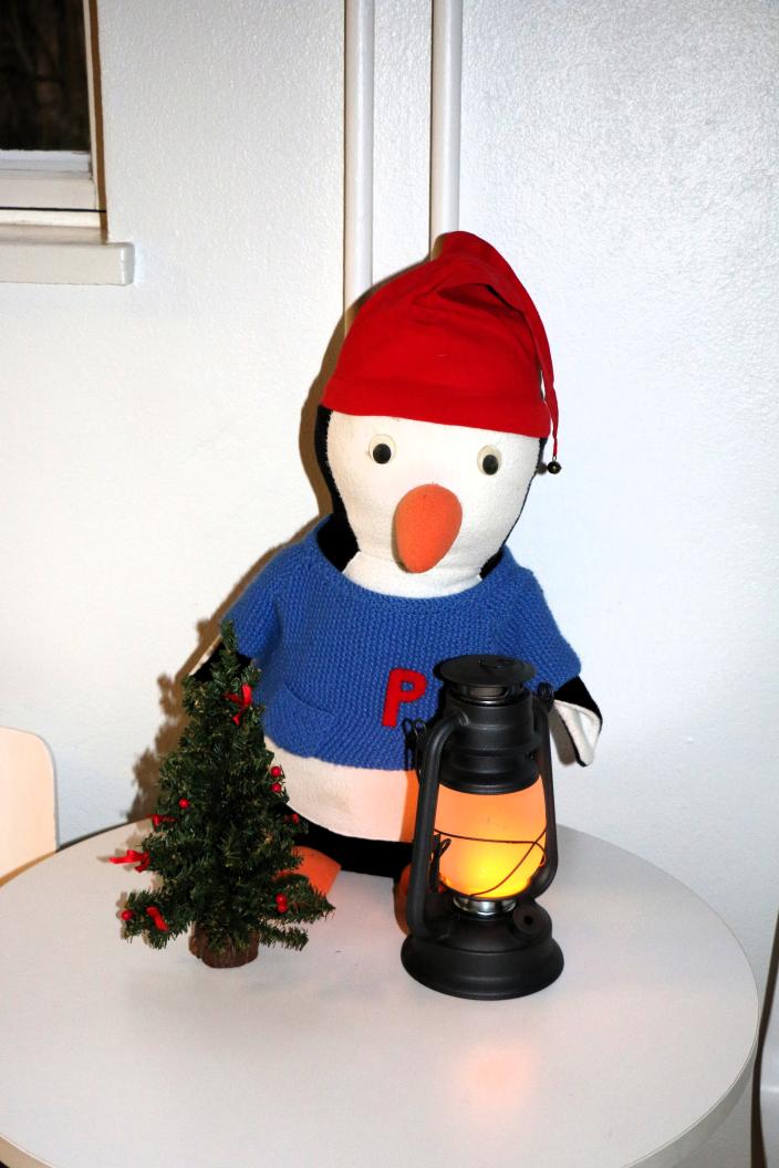 Pingviinipehmolelu tonttulakki päässä.