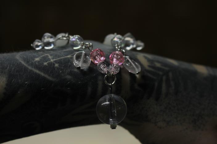 Kuvassa helmistä tehty koru on tatuoidun käden päällä. (Foto: Maria Marquis)