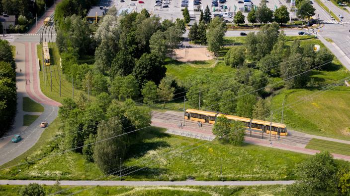 Havainnekuvassa keltainen raitiotie Jaaninojalla viheralueen keskellä. (Kuva: Turun raitiotieallianssi)