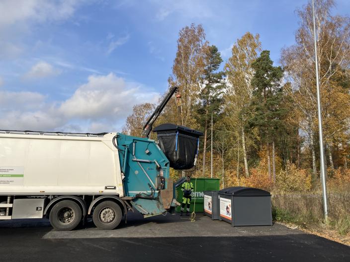Jäteauto tyhjentää nosturilla