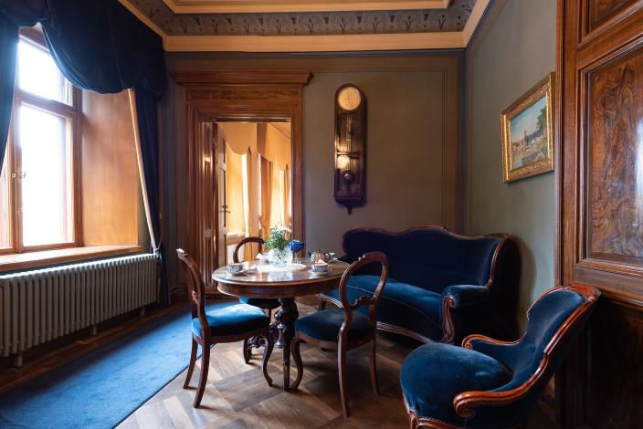 Tunnelmallisesti valaistu pieni sali, kulmassa vanhanaikainen sohvaryhmä. (Foto: Joonas Mäkivirta)