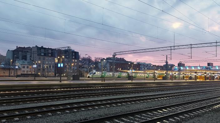 Raiteet ja niiden takana asemalta lähtevä juna. (Kuva: Päivi Autere)