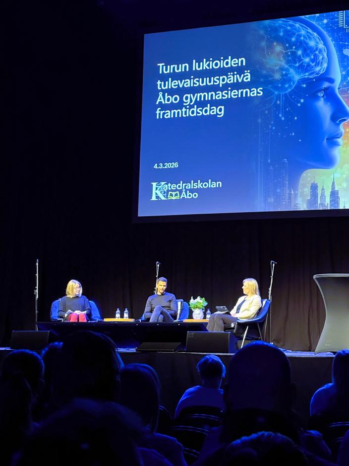 Kolme ihmistä keskustelemassa Logomon lavalla. 