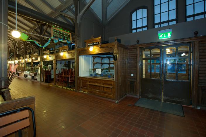 Isot heiluriovet vievät kauppahallin käytävältä Linnankadulle, ovien yllä vihreä hätäpoistumisvalo. (Kuva: Martti Puhakka, Turun kaupunginmuseo)