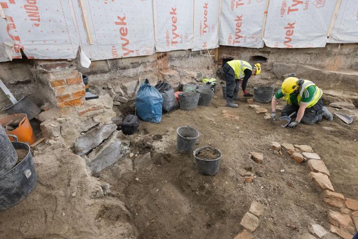 Arkeologeja kaivamassa työmaalla, maassa useita isoja astioita joissa maata ja löytöjä (Kuva: Ville Mäkilä, Turun kaupunginmuseo)