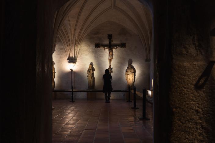 Museovierailija tunnelmoimassa Nunnakappelin pyhimysveistosten äärellä. (Kuva: Ville Mäkilä)