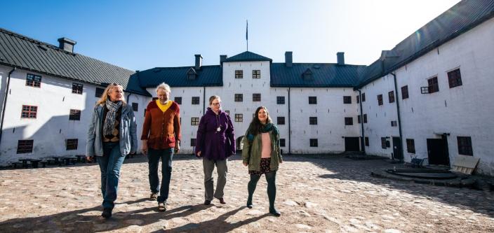 Medlemmar i Kimmoke-gruppen promenerar på Åbo slotts borggård. (Foto: Heikki Räisänen)