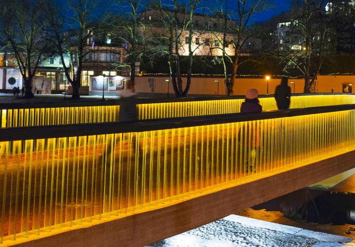 Kuva kirjastosillasta oranssiksi valaistuna.