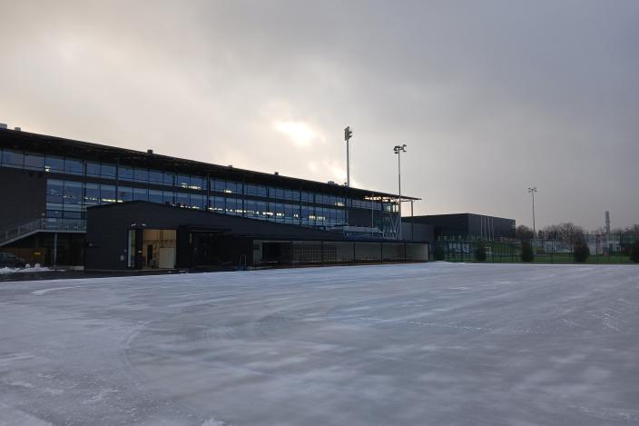 Kuvassa on jääkenttä. Taustalla katos ja sen takana rakennus.  (Foto: Ann-Marie Unkuri)