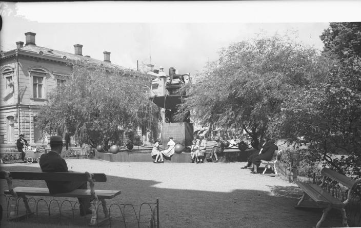 Vanha mustavalkoinen valokuva Vähätorilta, ihmisiä penkeillä istumassa ja taustalla hopeapajujen ympäröimä Leijona-suihkulähde. (Kuva: Turun Sanomat / Turun kaupunginmuseo)