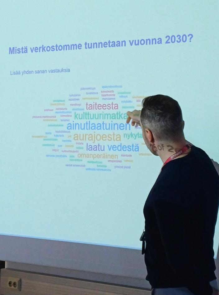 Matias Halmeenmäki esittelee sanapilveä, joka kuvaa mistä Kulttuurin jokirannan verkosto halutaan tunnettavan 2030. (Kuva: Heli Lempa)