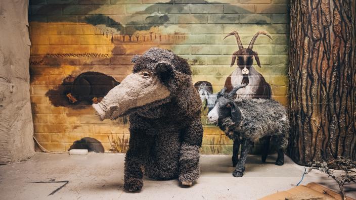 Kierrätysmateriaaleista valmistettu villisika ja vuohi ovat mukana Aikamatka 20360 -teoksessa, taustalla seinälle maalattuna on toinen vuohi ja kivikautista maisemaa. (Kuva: Jussi Virkkumaa)