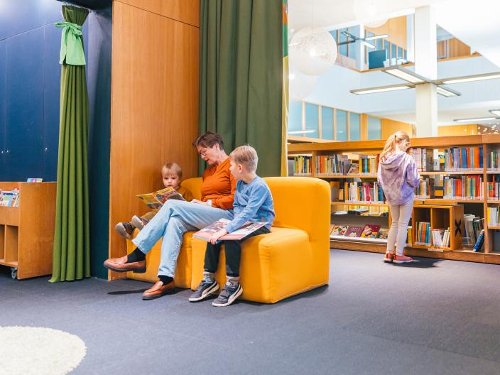 Aikuinen lukee lapsille kirjastossa. (Kuva: Heikki Räisänen)
