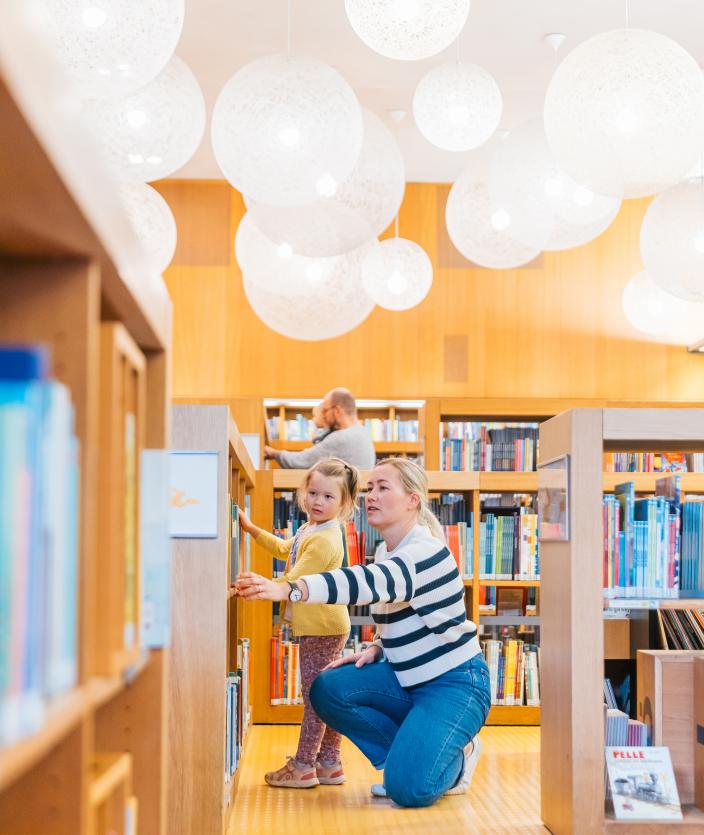 A child and an adult choosing a book in the library. (Picture: Heikki Räisänen)