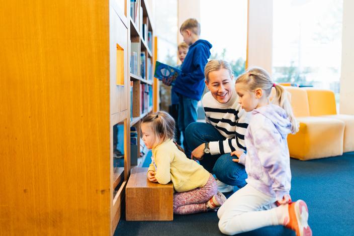 Lapsia ja aikuisia pääkirjaston lastenosastolla tutkimassa kirjoja ja vitriiniä. (Kuva: Heikki Räisänen)