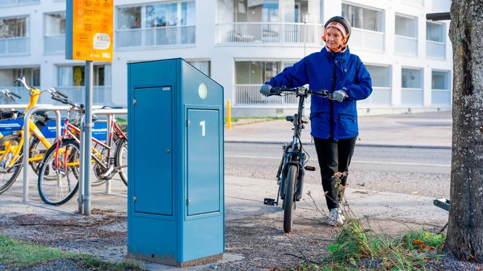 Kuvassa näkyy sähköpyörien latausasema ja pyöräilijä. (Kuva: RESPONSE-hanke)