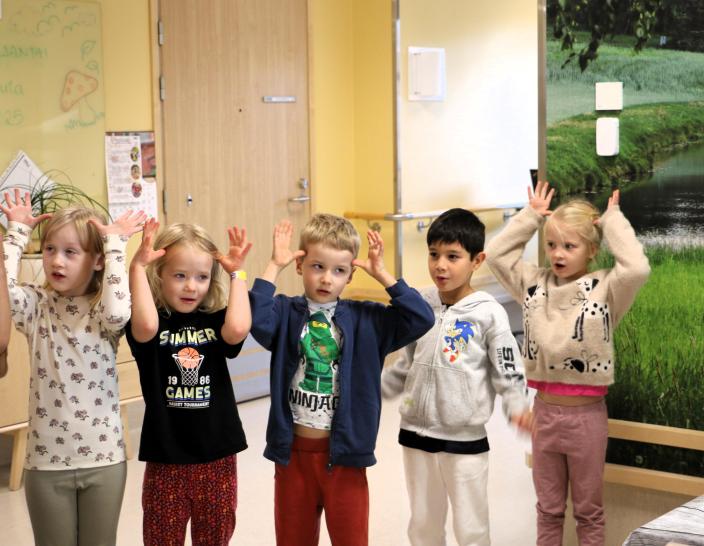 Fem barn sjunger och leker. (Foto: Hannele Sivonen)