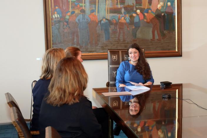 Ministeri Anna-Kaisa Ikonen istuu pöydän päässä, edessään hänelle luovutettu lausunto ja vierellä sen tuojia. (Kuva: Niina Sylgren)