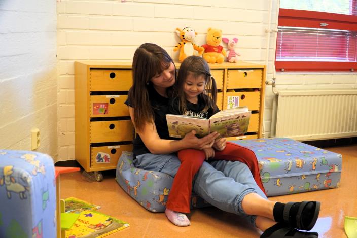 En vuxen som läser en bok för ett barn. (Foto: Hannele Sivonen)