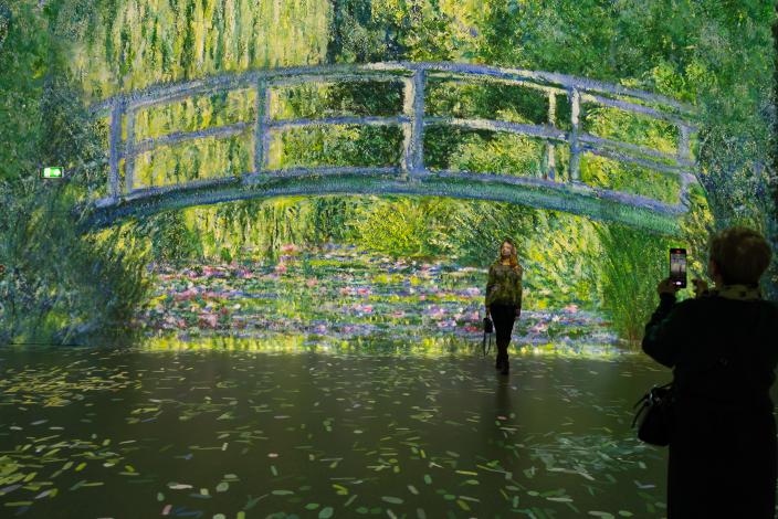 Frameless-näyttelyssä projisoidaan mestariteoksia pinnoille ja kuvassa näkyy Claude Monet'n lummelampi ja silta.