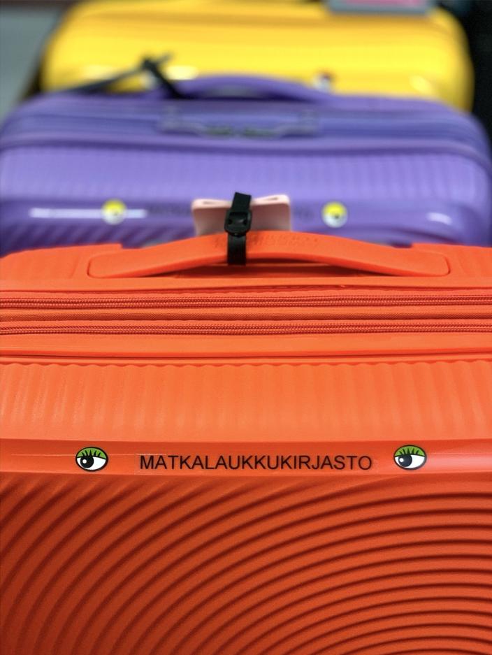 Eri värisiä matkalaukkuja jonossa. (Kuva: Satu Aalto)